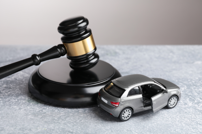 Motor vehicle accident law. Gavel and car model on grey background