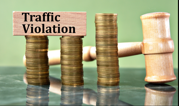 TRAFFIC VIOLATION - words on a white sheet with a judge's gavel and a stack of coins in the background