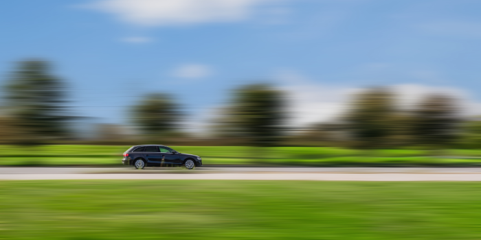 Side view of a fast moving car with a blurred background.