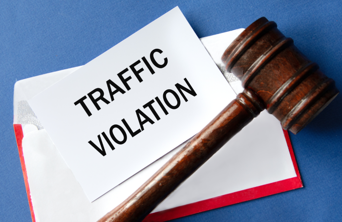 TRAFFIC VIOLATION - words on a white sheet of paper against the background of an envelope and a judge's gavel