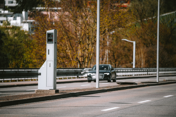 Gray, mobile, car traffic speed trap camera between two car lane.