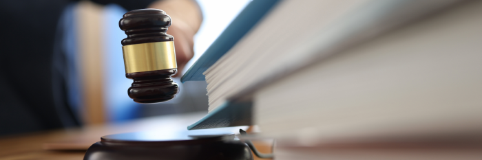 Wooden gavel for judge on table next to folder with documents. Justice and law enforcement concept