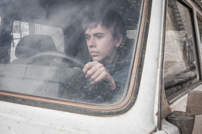 Young boy driving a car. Teen behind the wheel of a car. teenager stole a car