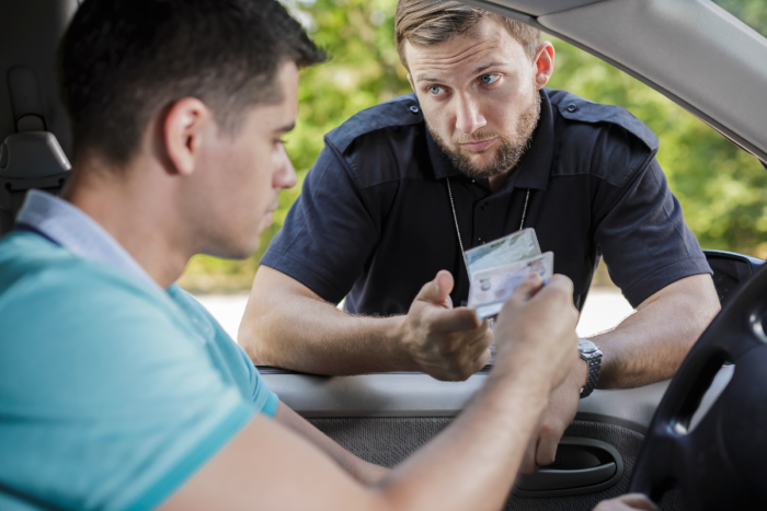 Policeman checking young male driver's documents