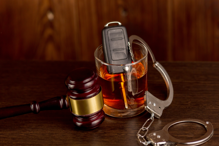 Whiskey with car keys and handcuffs. Concept for drinking and driving