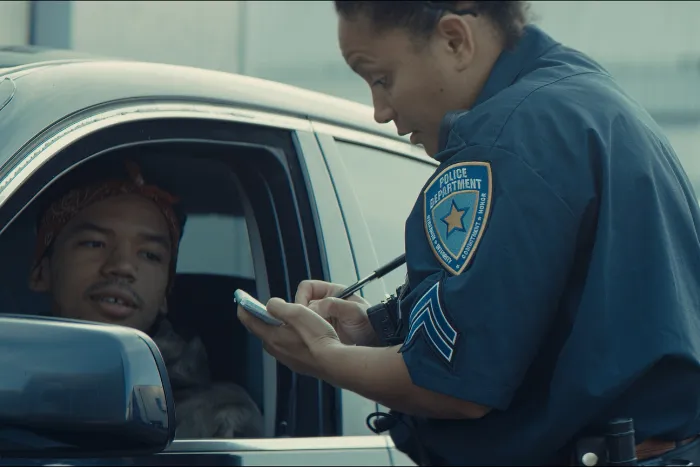 African-American black driver is being pulled off by mixed-race female police officer. Documents check, speeding ticket